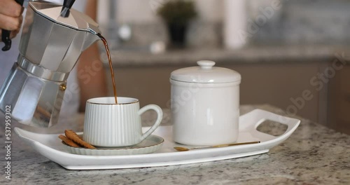 pouring coffee into a cup from de greek