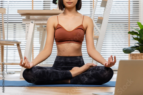 Young Asian woman doing yoga stretching yoga at home.Happy people stay home, doing aerobic exercise at living room Girl doing lockdown activity, workout with trainer for health in house.