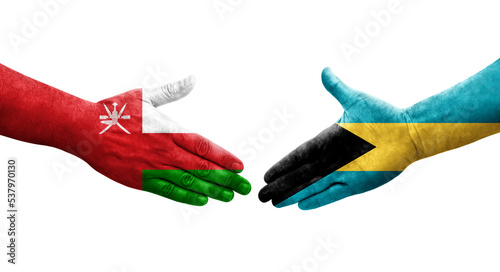 Handshake between Bahamas and Oman flags painted on hands  isolated transparent image.
