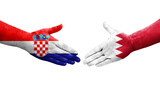 Handshake between Bahrain and Croatia flags painted on hands, isolated transparent image.