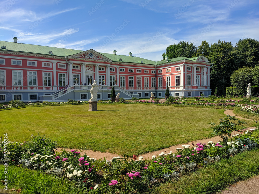 Moscow, Russia - August 13, 2022: View of the Kuskovo Palace, the former estate of the Sheremetevs in the museum of the Kuskovo estate. Near the building flowers grow on a green lawn