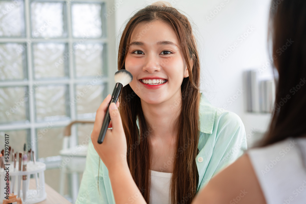 Beauty and cosmetic concept, Makeup artist using brush with blush on cheek and makeup of model Beauty and cosmetic concept, Makeup artist using brush with blush on cheek and makeup of model