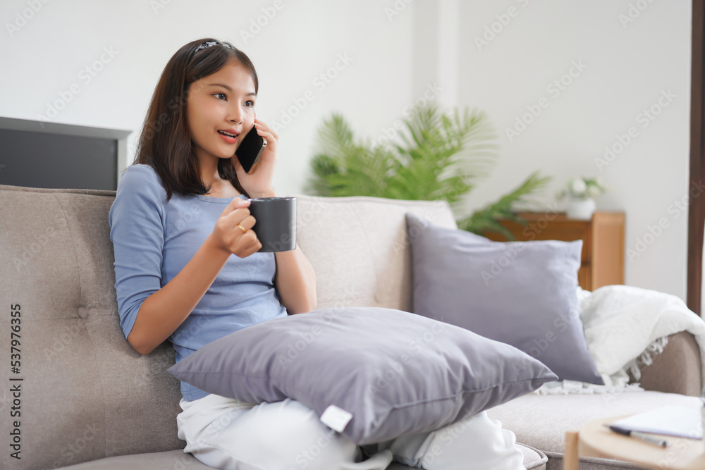 Work from home concept, Business women talk on phone with colleague while working on couch at home Work from home concept, Business women talk on phone with colleague while working on couch at home