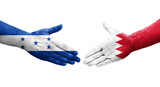 Handshake between Bahrain and Honduras flags painted on hands, isolated transparent image.