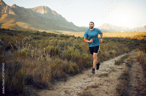 Fitness, mountain and runner running on a trail in nature for exercise, training and cardio workout outdoors. Sports, challenge and active athlete with endurance, discipline and healthy body in Italy © Kay Abrahams/peopleimages.com