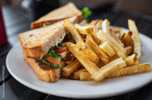 Club-sandwich with french fries on white plate. Veg grilled sandwich served with ketchup and Salted French fries