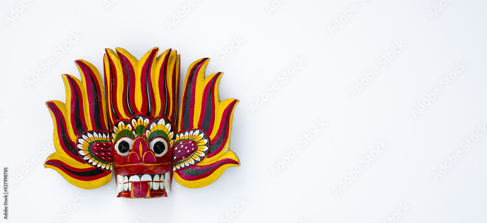 Obraz premium A red wooden mask on a white isolate.A souvenir from Thailand on a white background. The mask of the deity.