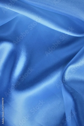 Beautiful light blue fabric, folded in soft folds. Silk, satin or satin.
