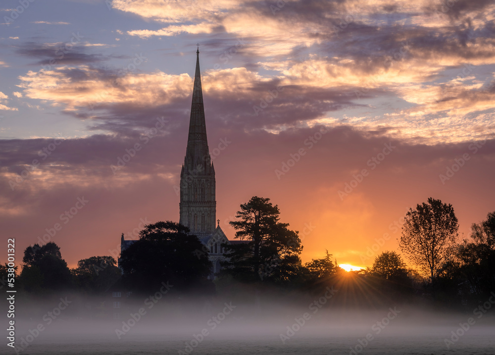 October misty morning sunrise behind Salisbury Cathedral from the Harnham water meadows Wilitshire south west England October misty morning sunrise behind Salisbury Cathedral from the Harnham water meadows Wilitshire south west England