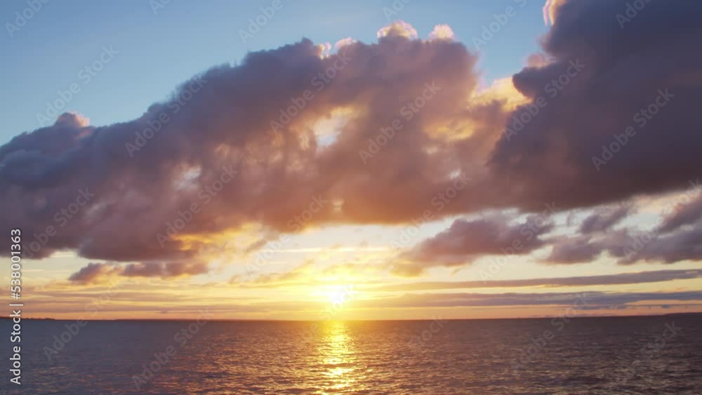 Timelapse with Sunset and Cumulus Clouds Flying High in a Beautiful Blue Sky. Sun Dawn in the Sea. Weather, Climate Change and Global Warming .