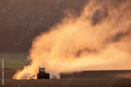 Tractor Tilling Empty Field Throwing up Dust at Sunset in Williamette Valley, Oregon, Autumn © Kirk