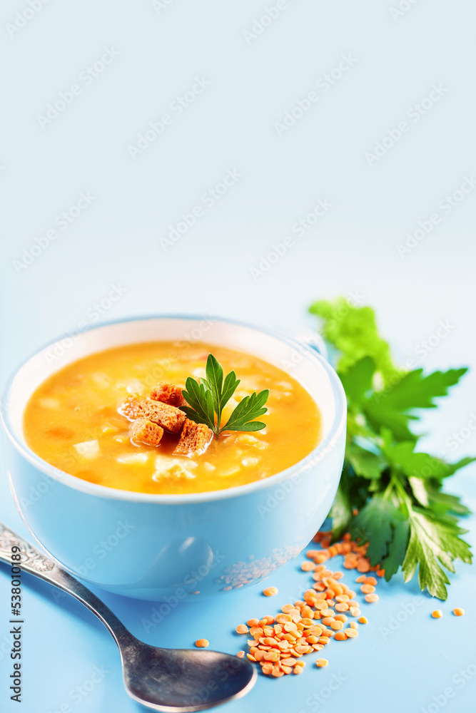 Pea lentil soup in a bowl on a blue background. Copy space. Vertical template Pea lentil soup in a bowl on a blue background. Copy space. Vertical template