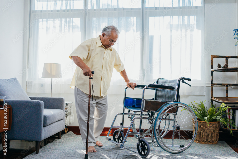 Asian senior old man with wheelchair walking with walker cane stick in nursing home, elderly mature disabled man patient, elderly health care concept. Photos | Adobe Stock