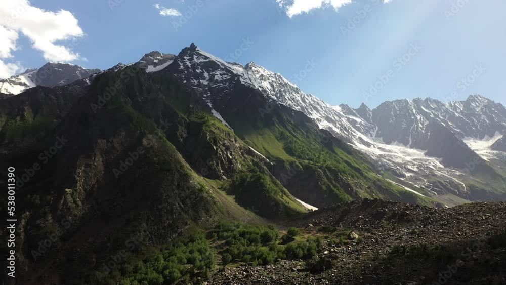 Aerial shot of the mountains valley and sun rays coming through clouds at Naltar Valley in Pakistan, epic rotating drone shot Aerial shot of the mountains valley and sun rays coming through clouds at Naltar Valley in Pakistan, epic rotating drone shot