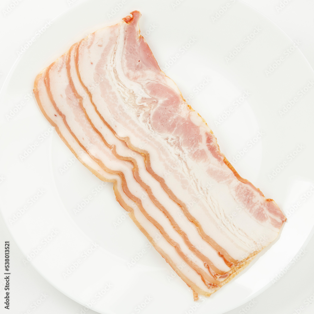Thin slices of bacon on a plate, smoked pork.