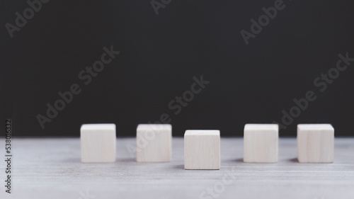 Row of five blank wooden blocks on a dark background with copyspace for your text, letters or numbers.