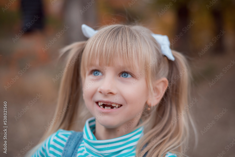 Portrait of a fair-haired girl. Blue-eyed girl with bows on her hair. Portrait of a fair-haired girl. Blue-eyed girl with bows on her hair.