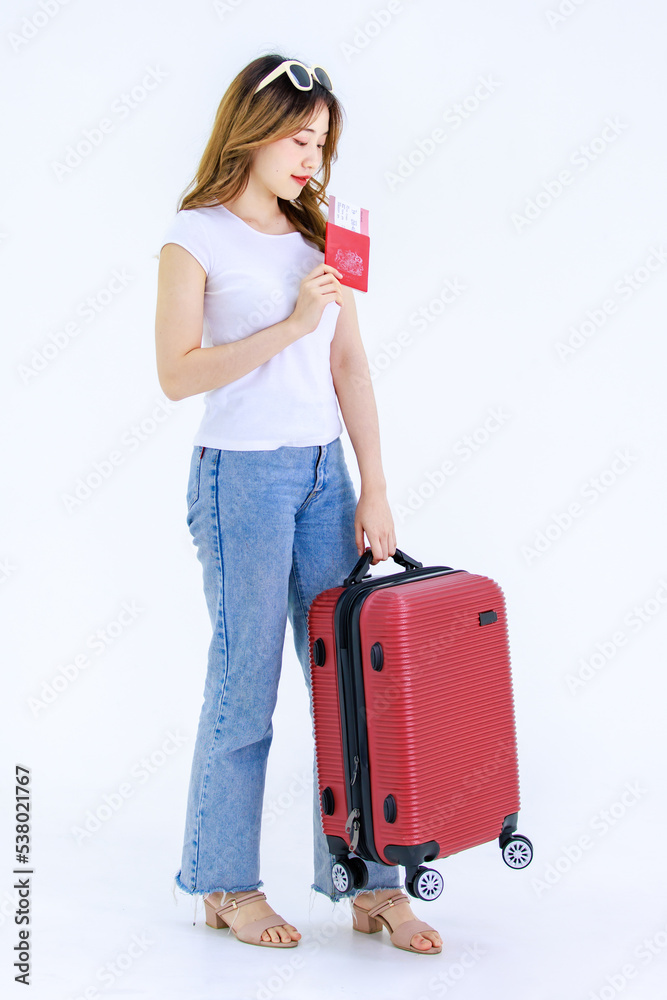 Isolated cutout studio full body shot of Millennial Asian young female teenager traveler in casual outfit standing holding passport boarding pass air ticket and trolley luggage on white background Isolated cutout studio full body shot of Millennial Asian young female teenager traveler in casual outfit standing holding passport boarding pass air ticket and trolley luggage on white background