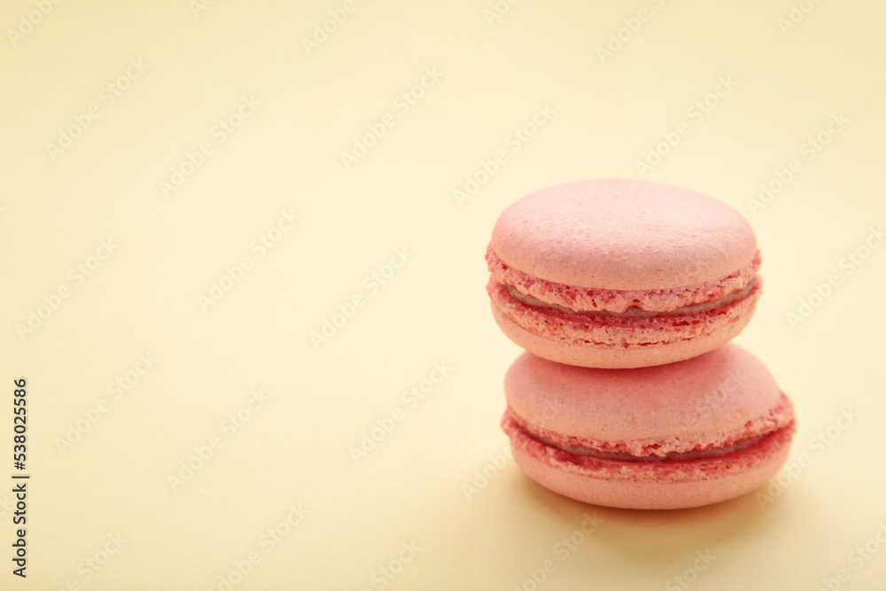 Sweet raspberries macarons on beige background. Space for text Sweet raspberries macarons on beige background. Space for text