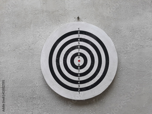 target with arrow. black white Darts board flippy knife game on the cement wall
