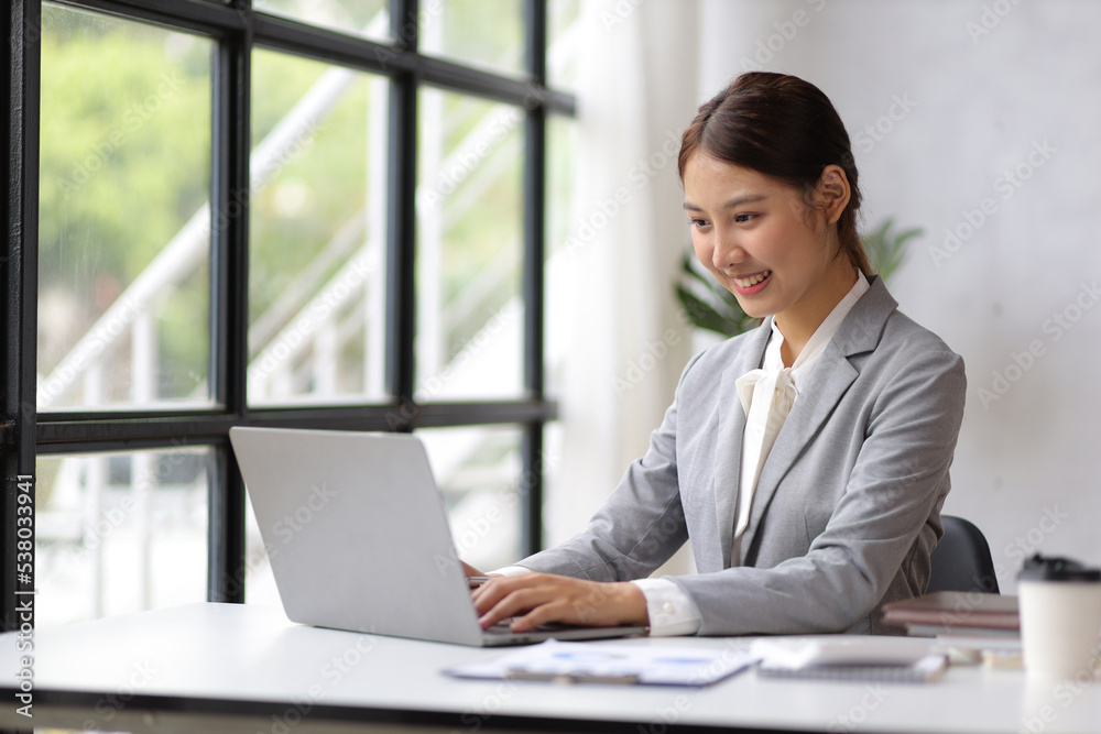 Young Asian business woman working on laptop and accounting in the office. Young Asian business woman working on laptop and accounting in the office.