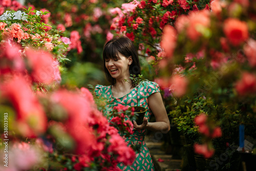 A bright happy girl among a garden of bright azaleas