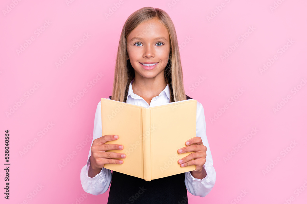 Photo of intelligent schoolkid reading homework novel in classroom isolated on pastel color background Photo of intelligent schoolkid reading homework novel in classroom isolated on pastel color background