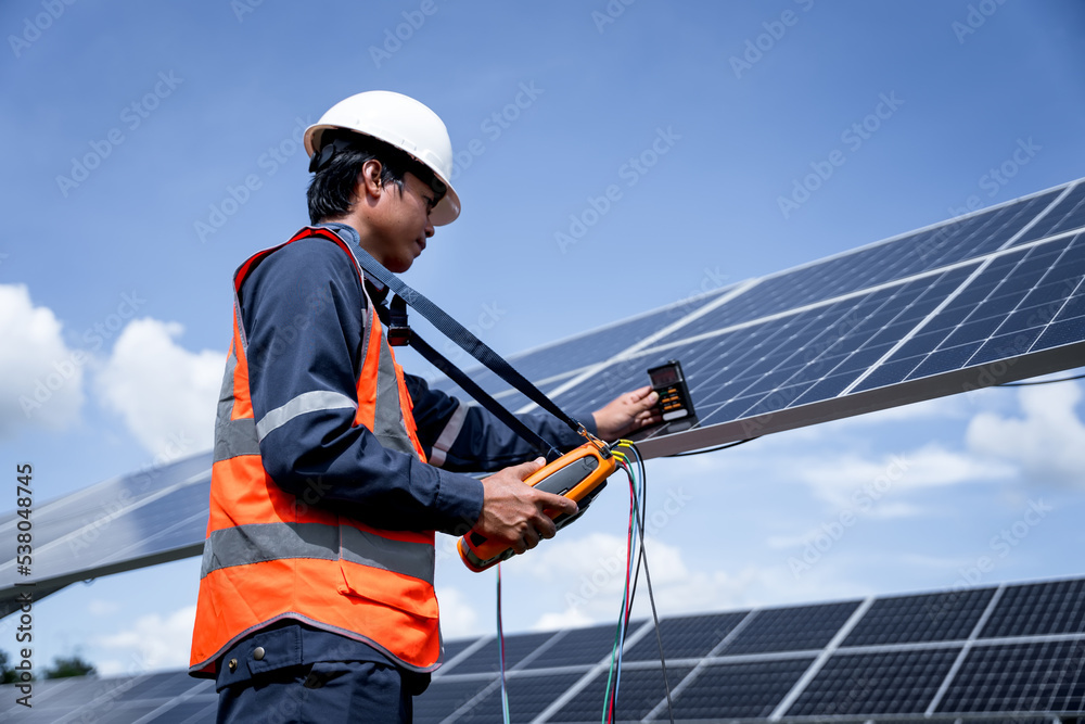 Engineers are checking the solar panels with a performance checker to verify that each solar panel is working at full efficiency. Alternative energy to conserve the world's energy. renewable business Engineers are checking the solar panels with a performance checker to verify that each solar panel is working at full efficiency. Alternative energy to conserve the world's energy. renewable business