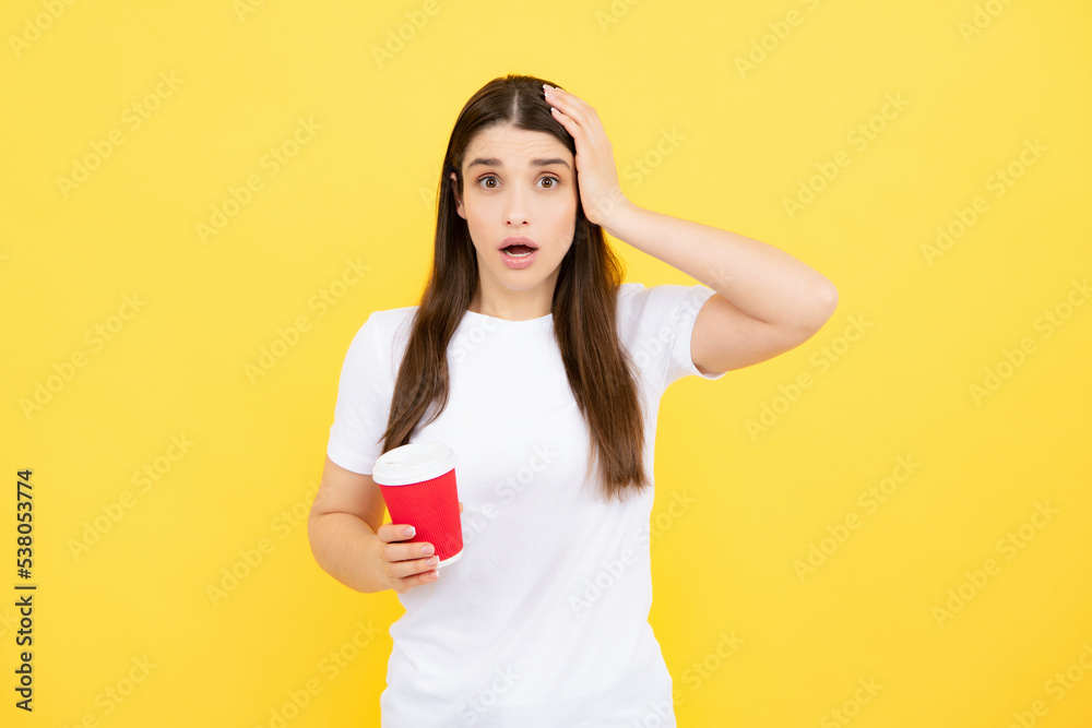 Close-up portrait of attractive dreamy girl holding in hands drinking latte isolated on yellow background. Young brunette woman drinking a cup of coffee. Close-up portrait of attractive dreamy girl holding in hands drinking latte isolated on yellow background. Young brunette woman drinking a cup of coffee.