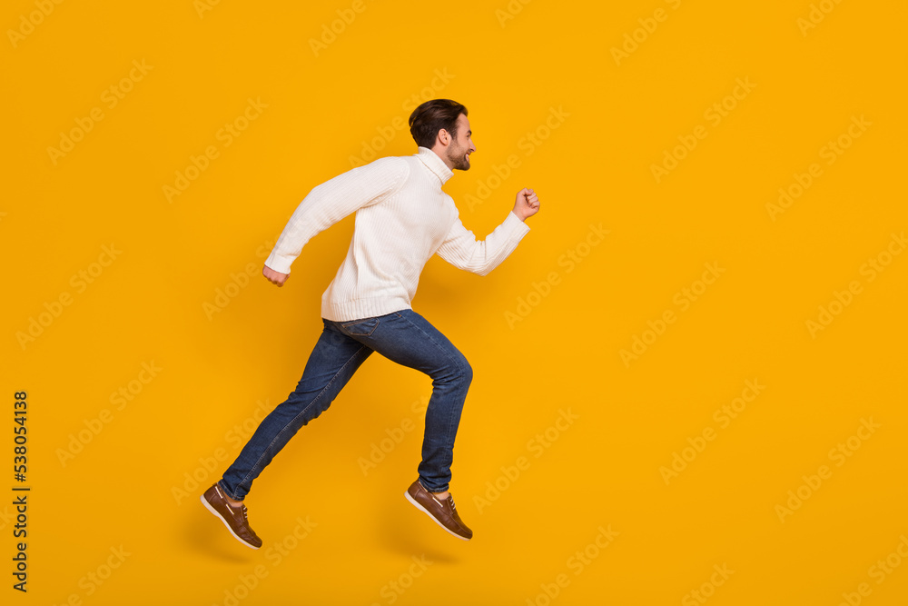 Photo of sweet attractive guy wear white pullover jumping high running fast isolated yellow color background
