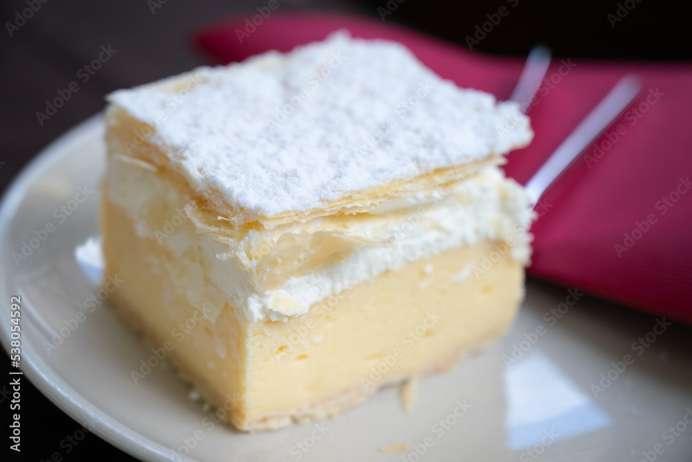 Close up of a Cremeschnitt, also known as vanilla slice or custard slice, is a custard and chantilly cream cake dessert commonly associated with the former Austro-Hungarian Monarchy Close up of a Cremeschnitt, also known as vanilla slice or custard slice, is a custard and chantilly cream cake dessert commonly associated with the former Austro-Hungarian Monarchy
