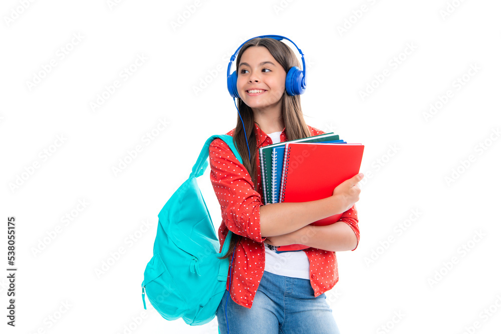 Schoolgirl, teenage student girl in headphones hold books on white isolated studio background. School and music education concept. Back to school. Portrait of happy smiling teenage child girl. Schoolgirl, teenage student girl in headphones hold books on white isolated studio background. School and music education concept. Back to school. Portrait of happy smiling teenage child girl.