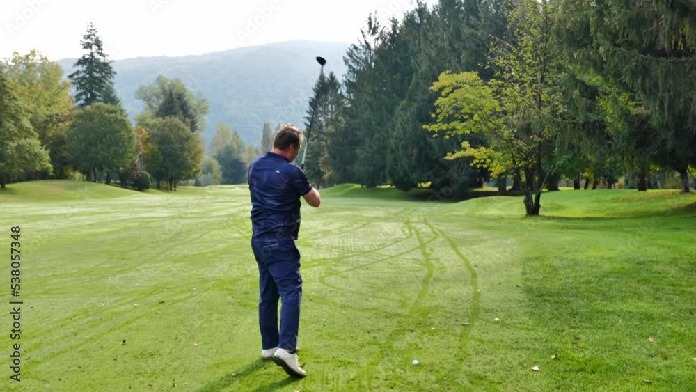 Golfer Hitting the Golf Ball on the Fairway with Sunlight in Switzerland. Golfer Hitting the Golf Ball on the Fairway with Sunlight in Switzerland.
