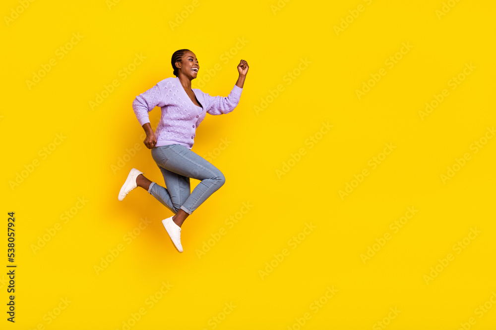 Full length profile portrait of active sporty lady run jump look empty space isolated on yellow color background