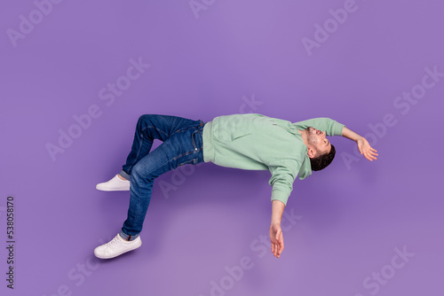 Full body photo of attractive young guy falling down height dangerous wear trendy gray garment isolated on violet color background