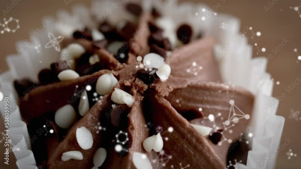Animation of molecules falling over chocolate cupcake Animation of molecules falling over chocolate cupcake