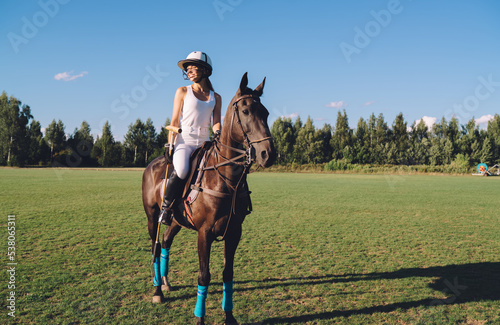 Smiling female jockey sitting on horse