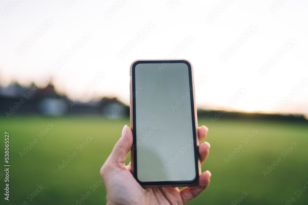 Faceless person taking photo of nature on cellphone