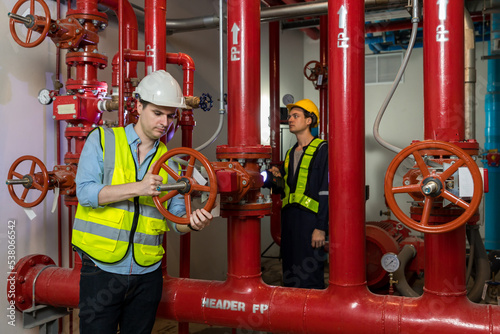 Engineer or technician work checking Fire suppression system and fire equipment. Engineer check red generator pump for water sprinkler piping and fire alarm control system