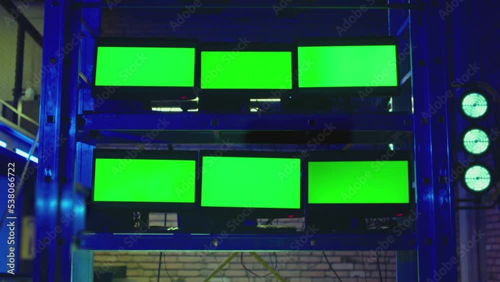A lot of monitors with green screen in dark modern room. Concept of monitoring , trading , analysing room and security systems . Video Switcher , many Screens for Broadcasting Live at Tv Control place A lot of monitors with green screen in dark modern room. Concept of monitoring , trading , analysing room and security systems . Video Switcher , many Screens for Broadcasting Live at Tv Control place
