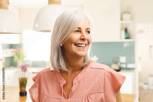 Happy senior caucasian woman smiling in kitchen