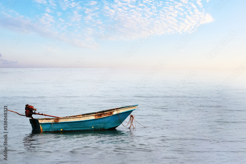 A small fishing boat floating in the ocean with summer morning bright sky and clouds image for background use. A small fishing boat floating in the ocean with summer morning bright sky and clouds image for background use.