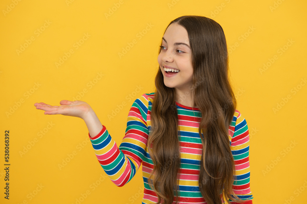 Close-up portrait of her she nice cute attractive cheerful amazed girl pointing aside on copy space isolated on yellow background. Mock up copyspace.