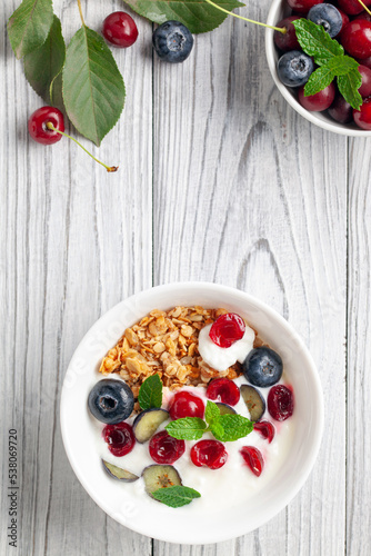 Cherry and blueberry granola with yogurt. Healthy food, diet breakfast. Top view