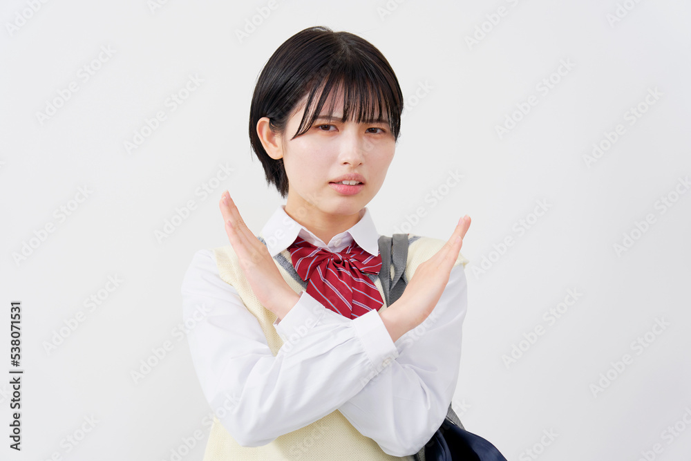 腕でばつ印する高校生　白背景