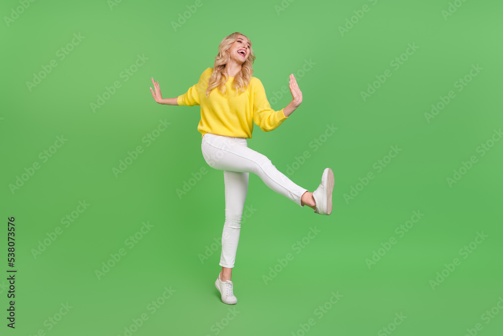 Full size photo of optimistic young blond dance wear ears pullover trousers sneakers isolated on green background Full size photo of optimistic young blond dance wear ears pullover trousers sneakers isolated on green background