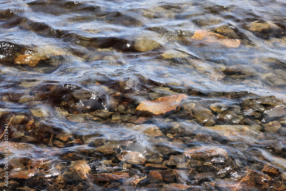 Stones under clear water with ripples Stones under clear water with ripples