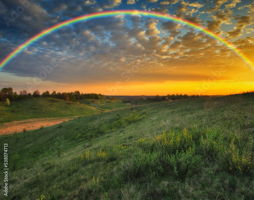 Rainbow over the meadow. picturesque spring morning. nature of Ukraine