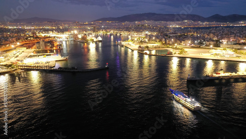 Aerial drone night shot of passenger ferry arriving to famous passenger port of Piraeus one of the largest in Europe, Attica, Greece © aerial-drone