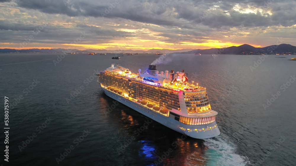 Aerial drone photo of huge illuminated cruise liner ship cruising to popular Aegean destinations at dusk with beautiful colours